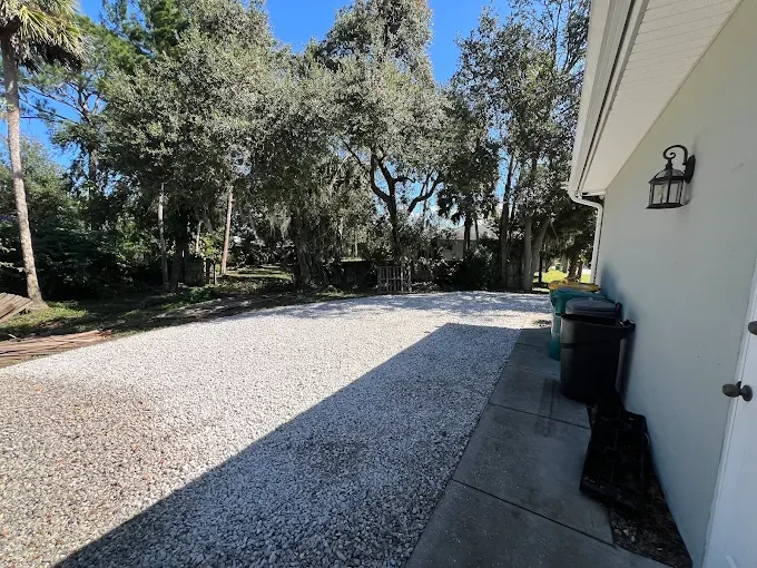 Custom outdoor living and landscape design featuring composite decking, decorative pavers, artificial turf, fire pits, flower beds, and backyard entertainment spaces in Brevard County.
