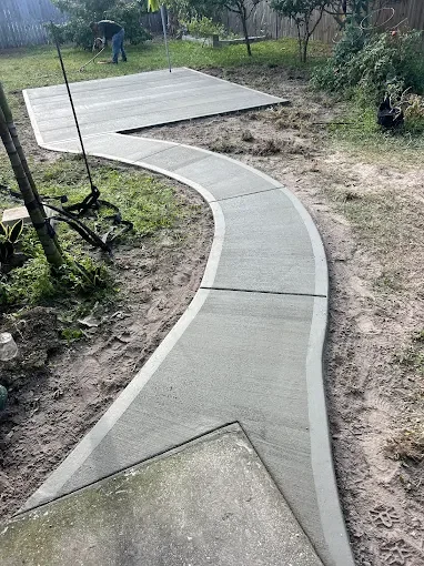 Custom outdoor living and landscape design featuring composite decking, decorative pavers, artificial turf, fire pits, flower beds, and backyard entertainment spaces in Brevard County.