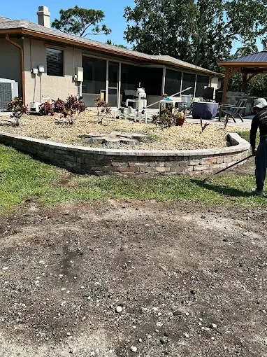 Custom outdoor living and landscape design featuring composite decking, decorative pavers, artificial turf, fire pits, flower beds, and backyard entertainment spaces in Brevard County.