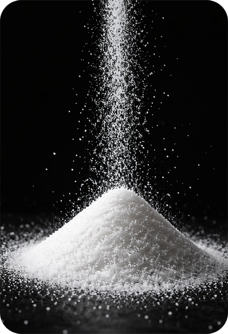 White salt being poured onto a pile on a black background.
