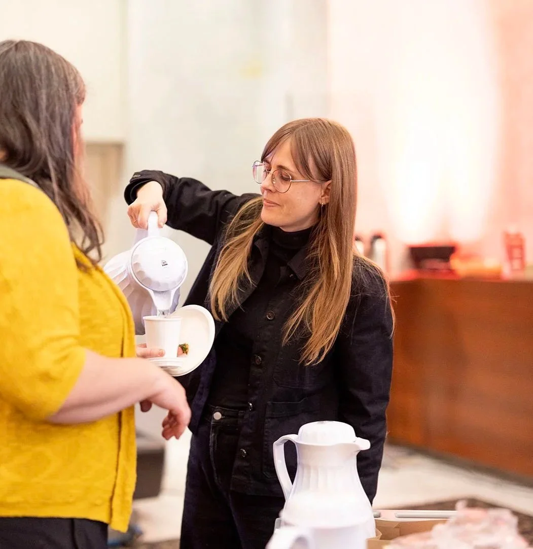 Une femme verse du thé dans une tasse pour une autre femme dans un intérieur chaleureux avec un point de vue en gros plan.