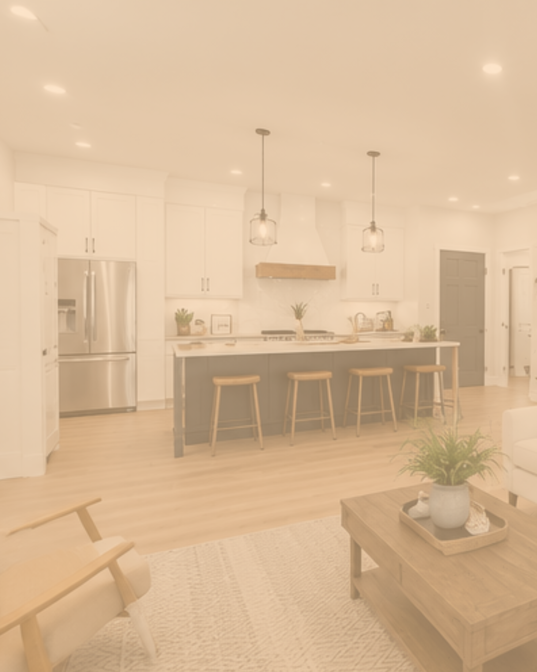 Bright modern open-concept kitchen with white cabinets, stainless steel refrigerator, island with wooden stools, and pendant lighting