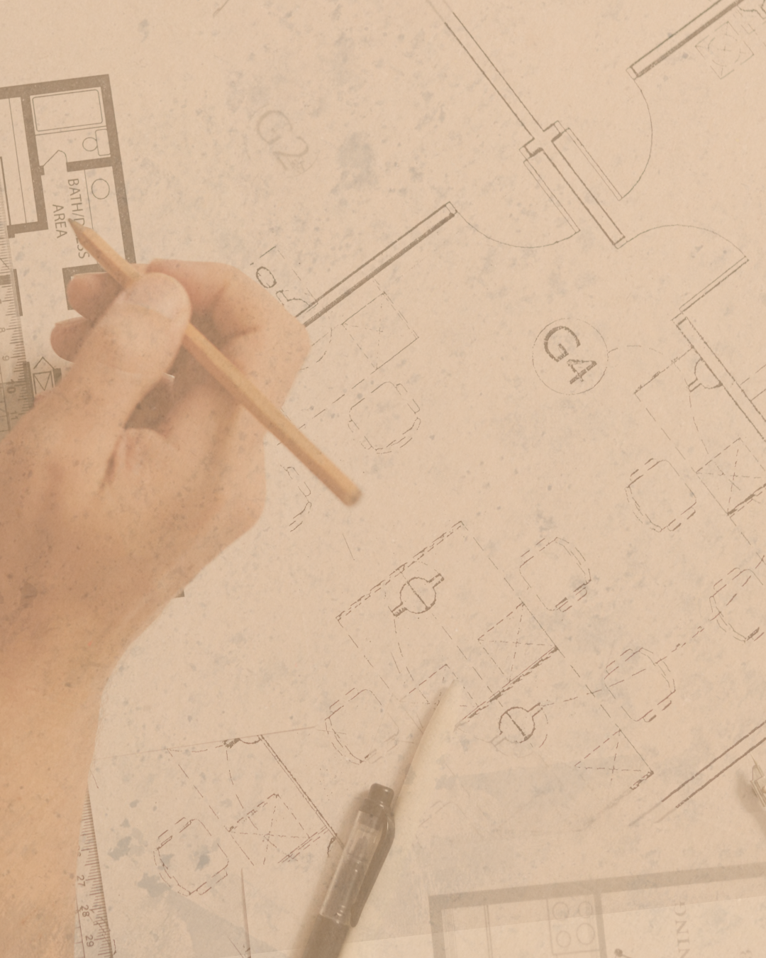 An architect is sketching a building floor plan on tracing paper with a pencil, surrounded by drafting tools like a ruler and a pen.