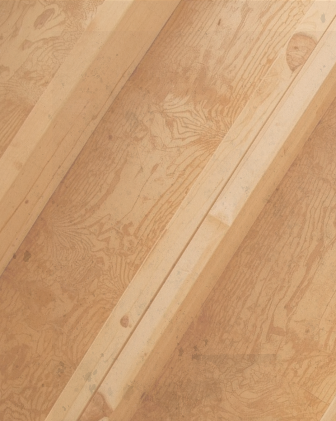 Close-up of a wooden surface with natural wood grain and some small imperfections.