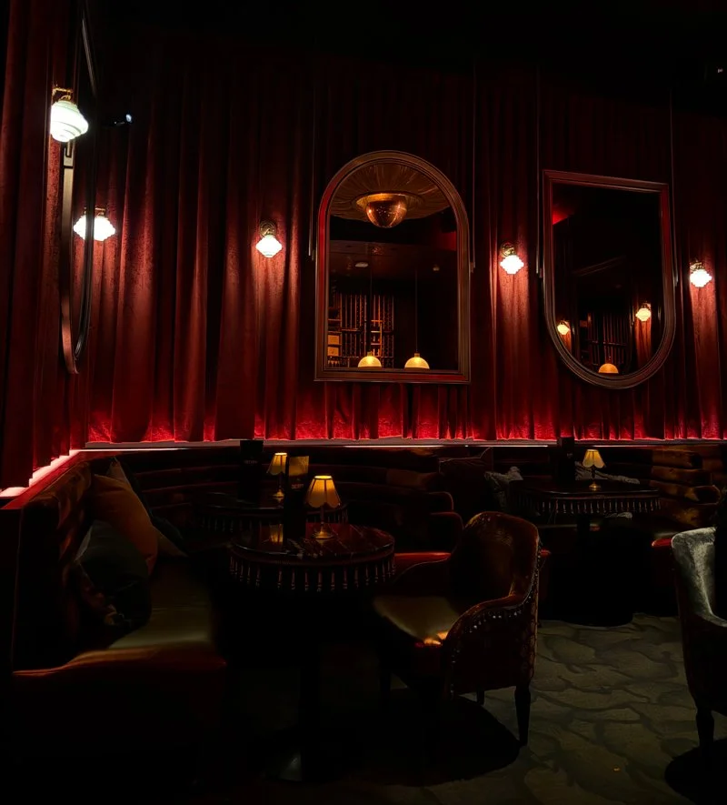 A regal restaurant with deep red drapery on the walls sits empty, waiting for coven members to take a seat