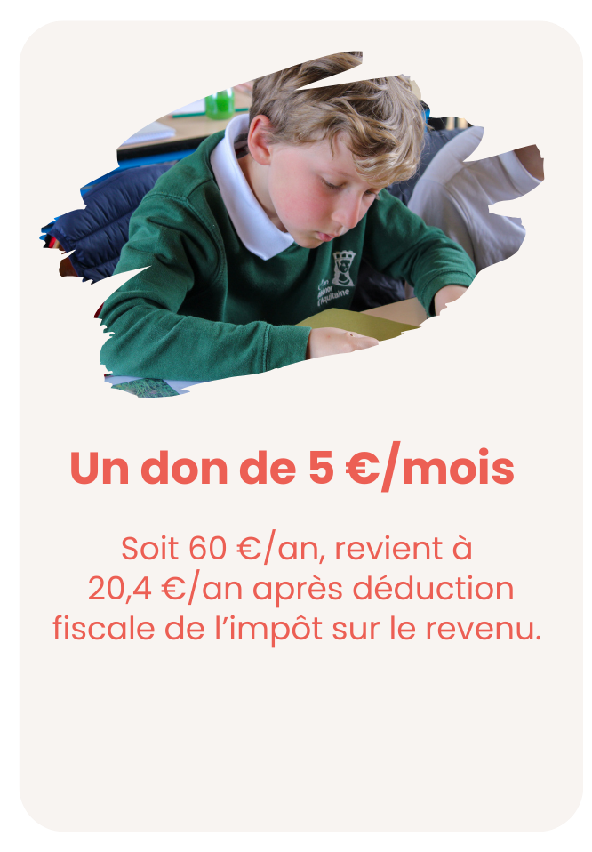 Jeune garçon en uniforme scolaire vert assis à une table en train de lire ou d'écrire, dans une salle de classe.