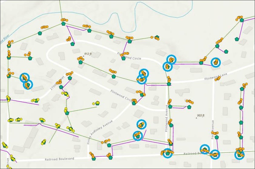 A map showing a neighborhood with streets, houses, and a network of colored lines and icons indicating specific data points, such as clusters of icons marked by blue circles, along various streets.