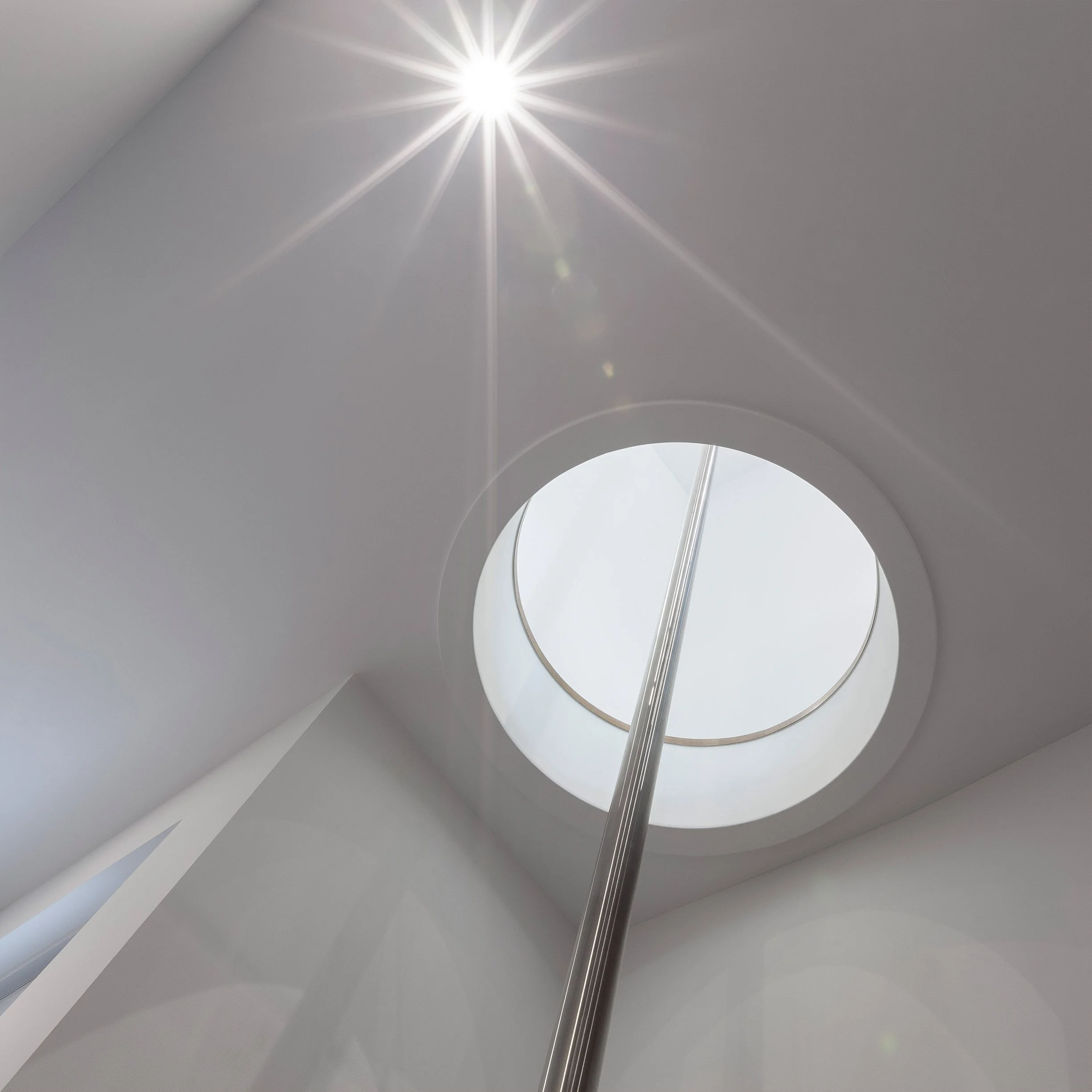Fun House ceiling detail in East York, Toronto, built by Maxamin Homes, showing skylight through circular opening with sunlight and starburst effect.