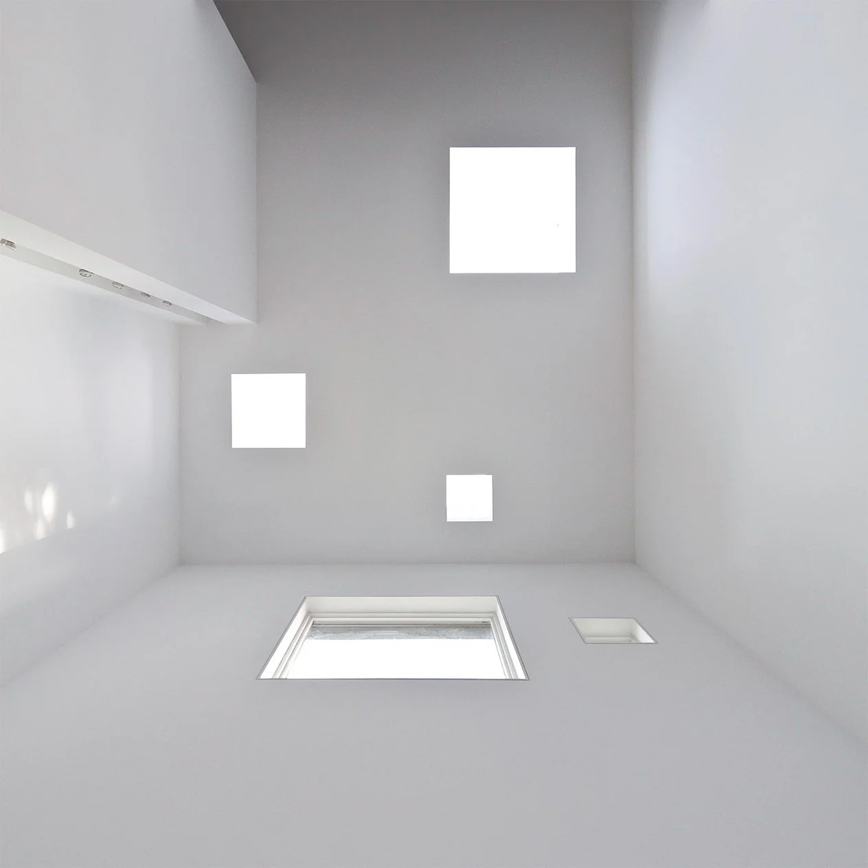 Image of a white ceiling with multiple square skylights.