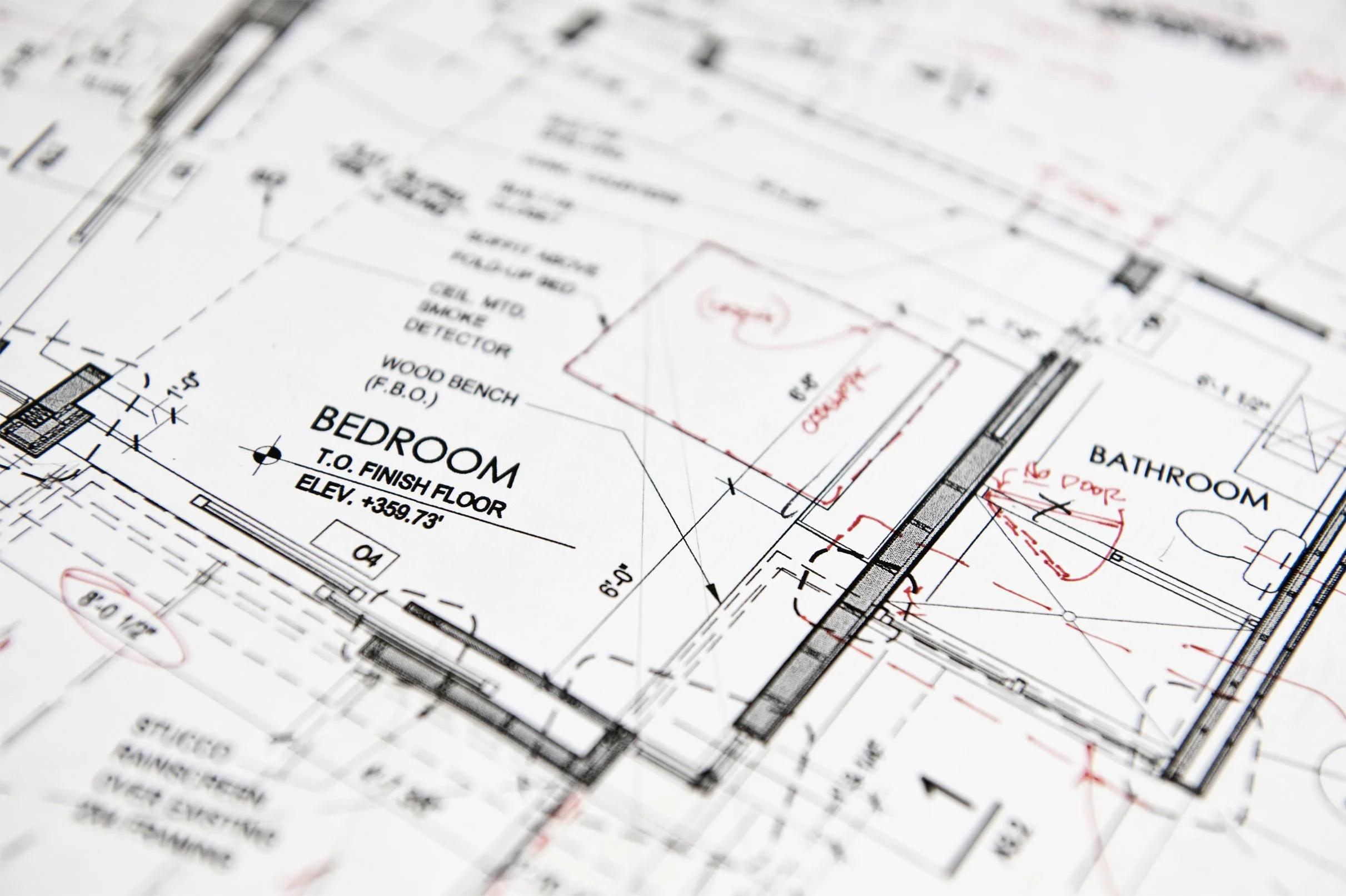 Architectural blueprint of a bedroom and bathroom, showing room dimensions, construction details, and notes in red ink.