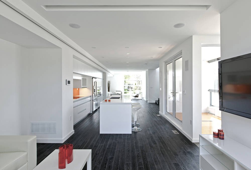 Patio House interior in North York, Toronto, built by Maxamin Homes, open-concept living area with white walls, dark floors, and modern furnishings.