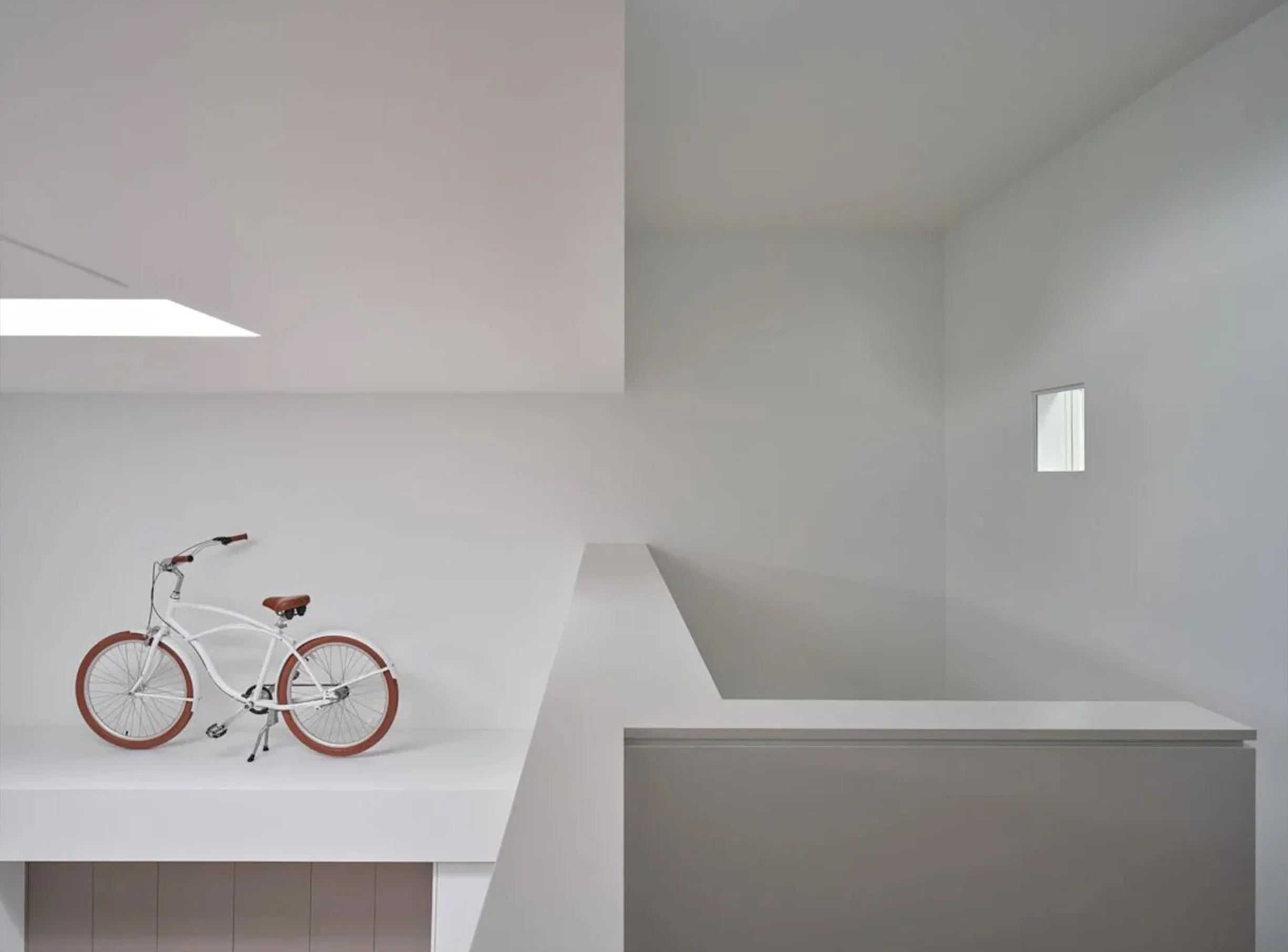 Periscope House interior in East York, Toronto, built by Maxamin Homes, minimalist white room with bicycle, geometric details, and small window.