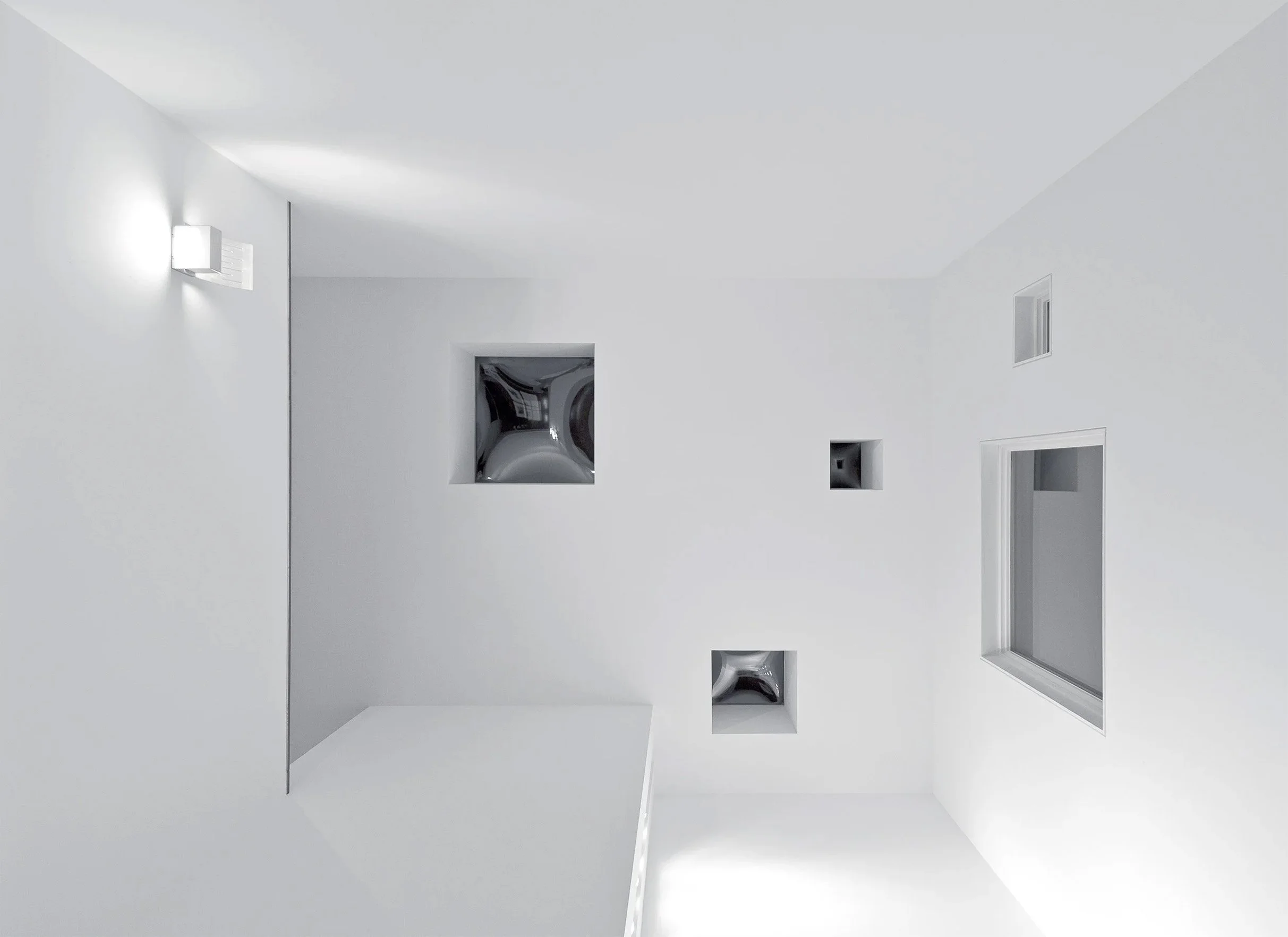 White room with ceiling vents, window, and wall lights, minimalist design.