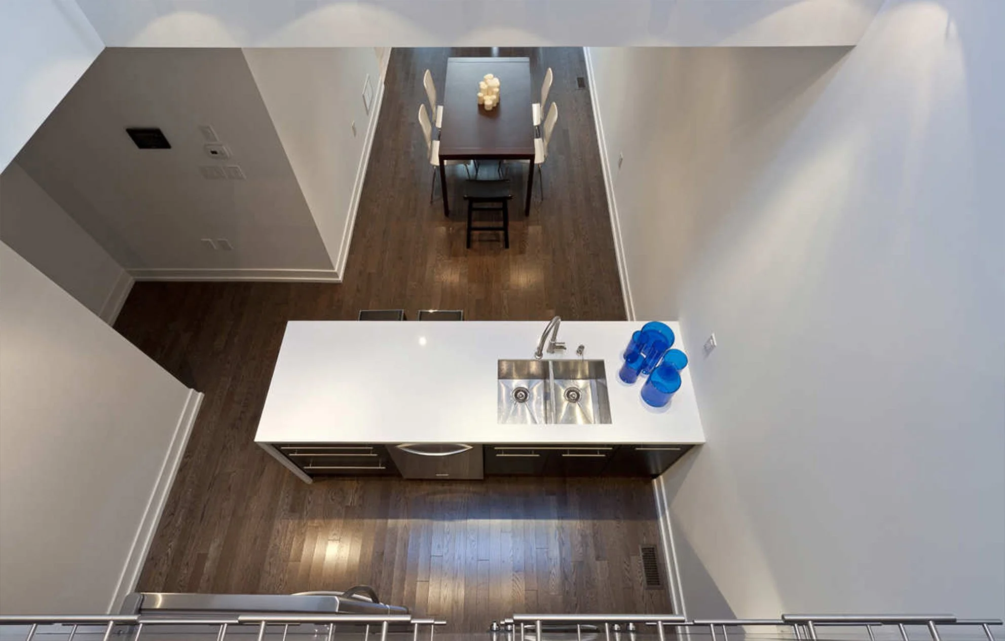 Charcoal House kitchen and dining area in East York, Toronto, built by Maxamin Homes, with dark wood table, black cabinetry, and white countertop.