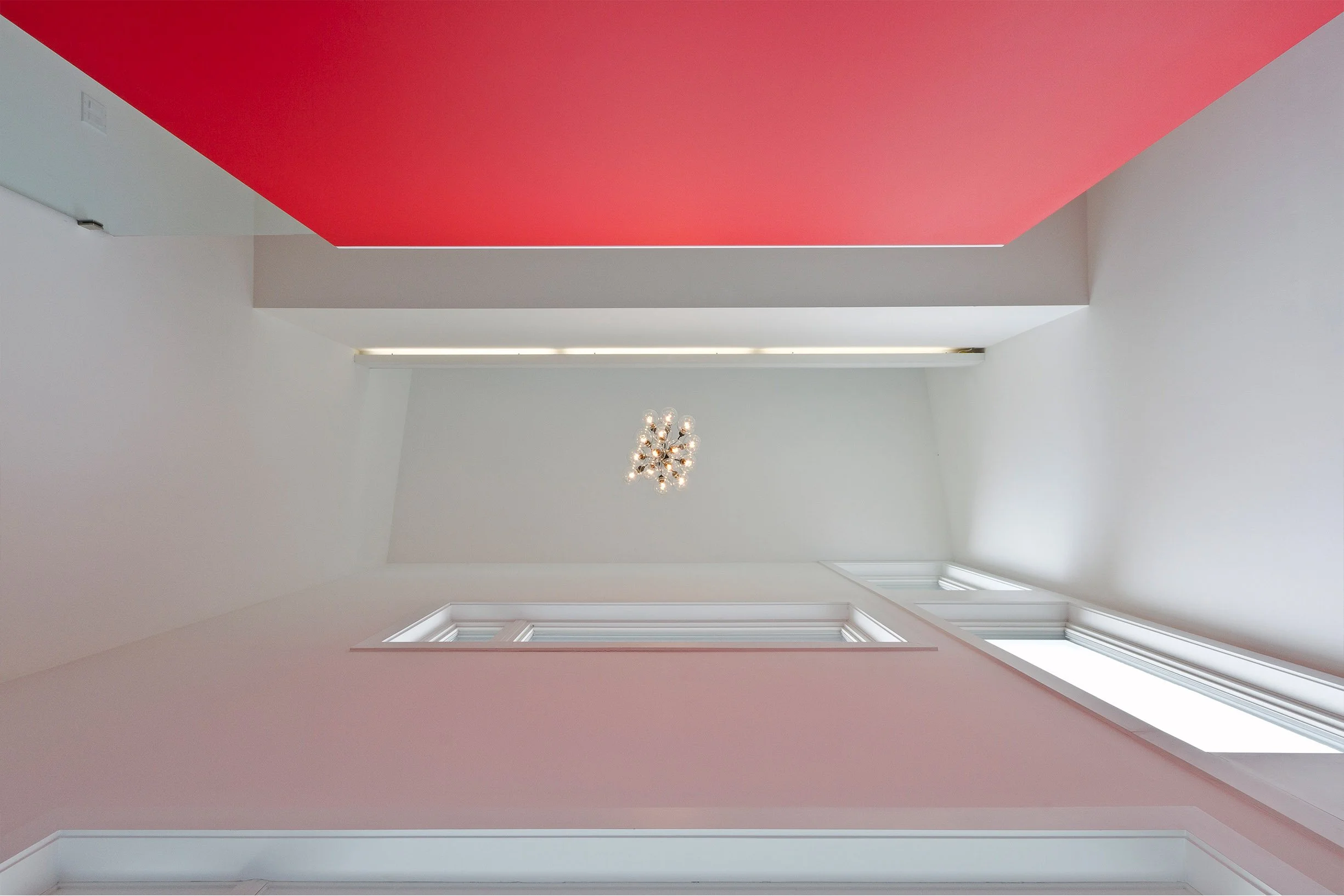 Whale House interior ceiling in East York, Toronto, built by Maxamin Homes, with pitched roof, white walls, chandelier, and windows.