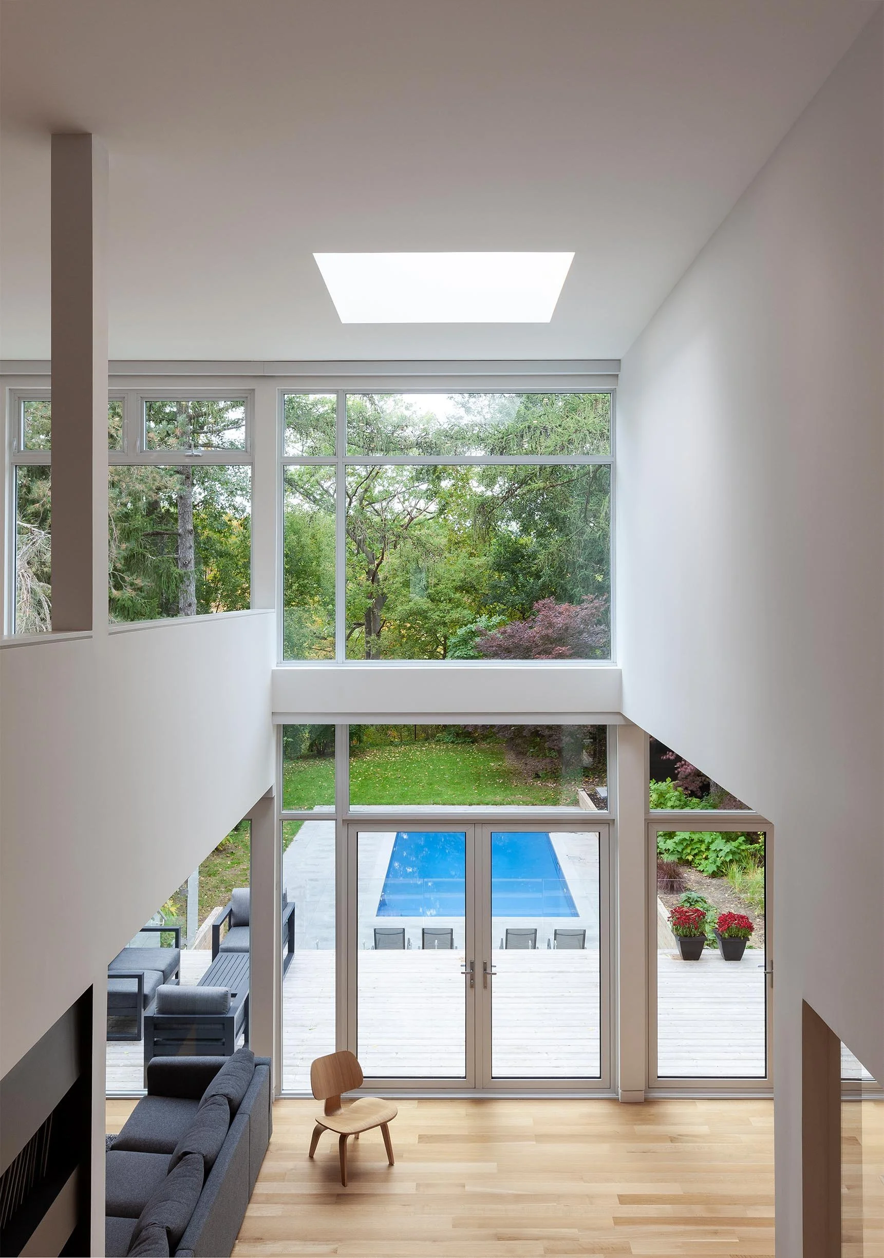 Fun House living room in East York, Toronto, built by Maxamin Homes, with floor-to-ceiling windows, wood flooring, and access to backyard pool.