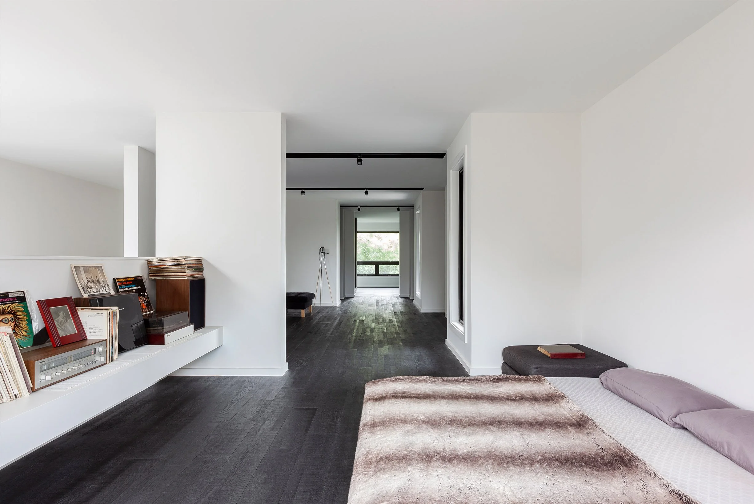 Ebenos House, a minimalist bedroom in North York, Toronto, with white walls, dark floors, gray bedding, and balcony view built by Maxamin Homes.