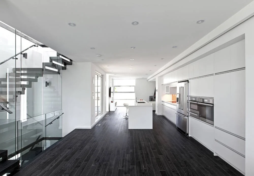 Patio House interior in North York, Toronto, built by Maxamin Homes, open-concept living area with white walls, dark floors, and modern furnishings.