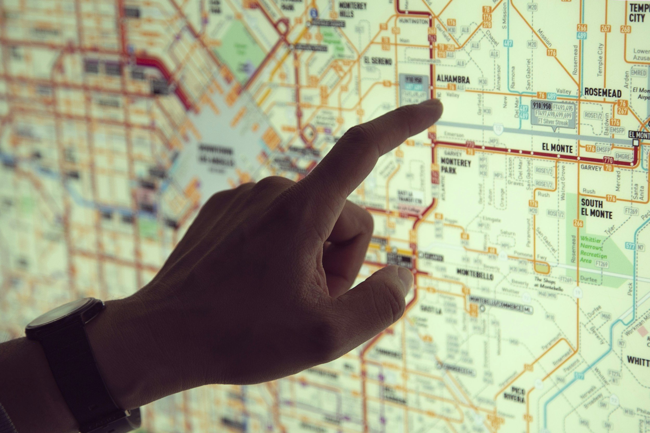 A hand pointing to a map of a city