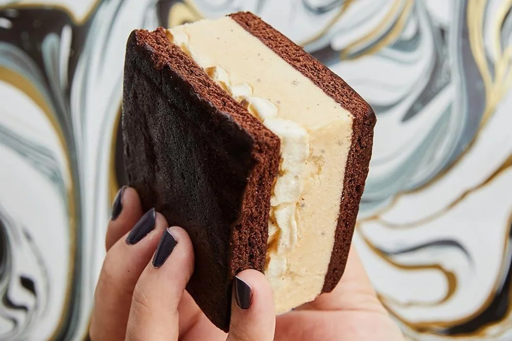 Close-up of an ice cream sandwich with vanilla filling between chocolate cookies from Lick Honest Ice Creams