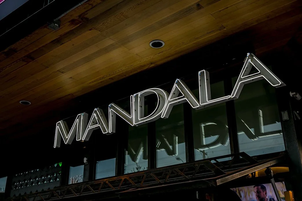 Neon sign reading “Mandala” on a building exterior
