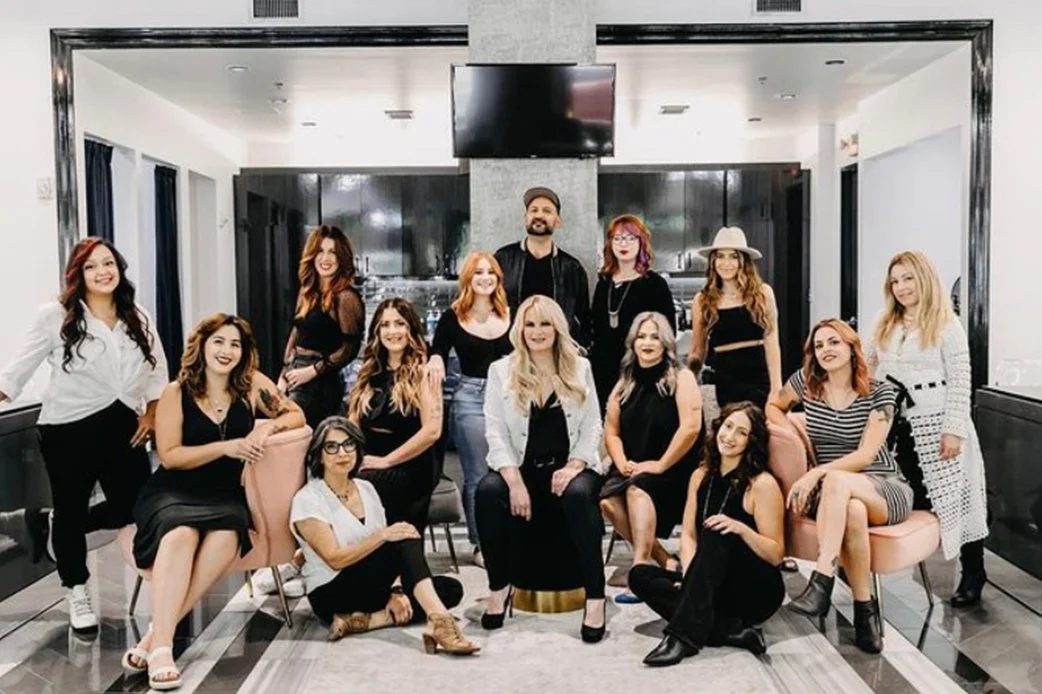Group photo of The Collective ATX salon team inside the salon, posing together and smiling