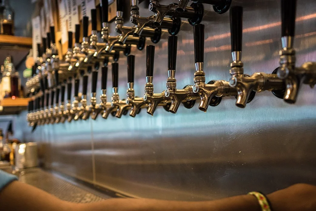 Beer taps lined up behind the bar at TLC Lamar Union