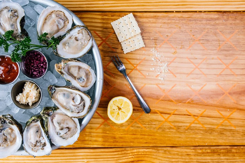 Fresh oysters on ice with lemon, cocktail sauce, and crackers at TLC Lamar Union