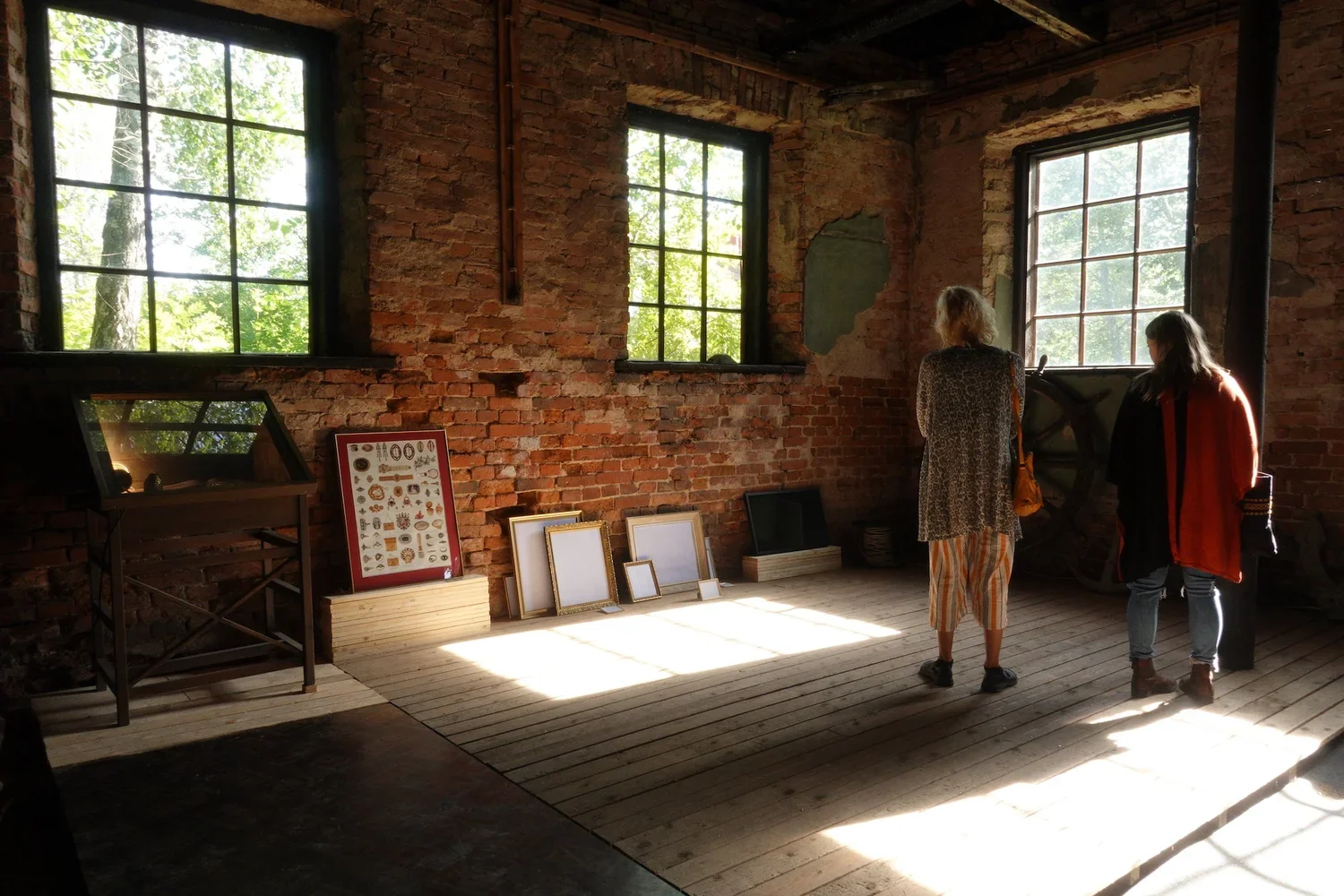  Lesley-Anne Cao, Arrangement (Golds), 2019.  Found frames, tarpaulin, eyelets, framed poster borrowed from the public library of Dalsbruk in Finland, work glove, round bells, dragon egg by Lisa Roberts,  book (‘Gold’ by Susan La Niece, The British M