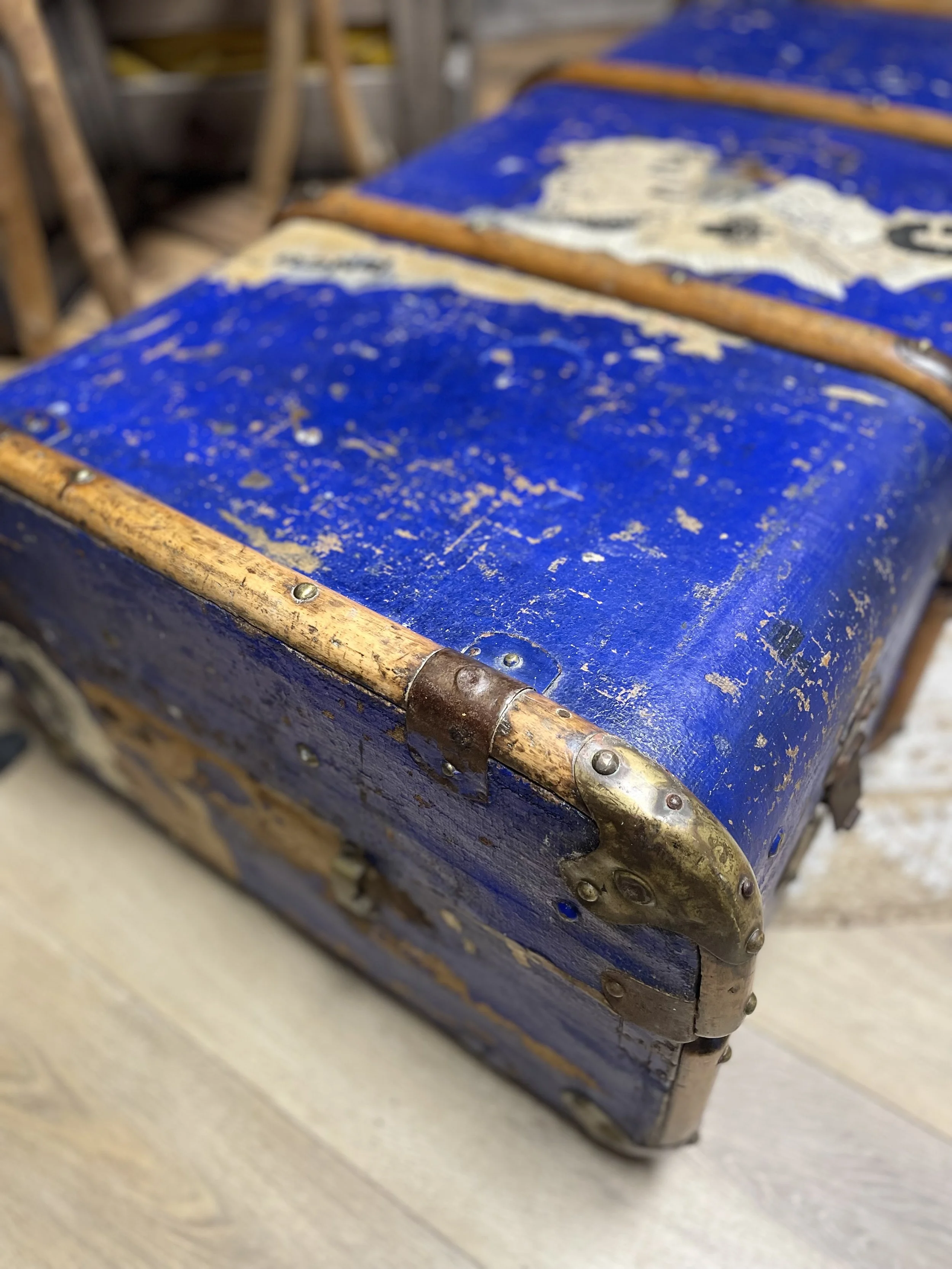 Coffre en bois peint en bleu, usé avec des ferrures en métal vieilli.