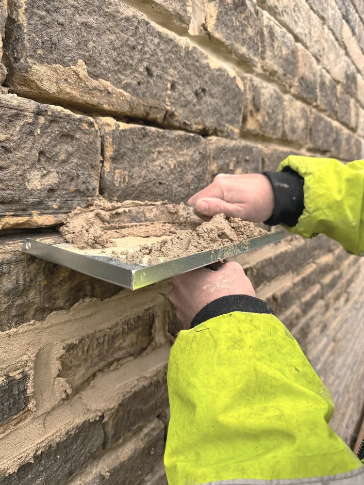 Applying mortar carefully to a masonry wall
