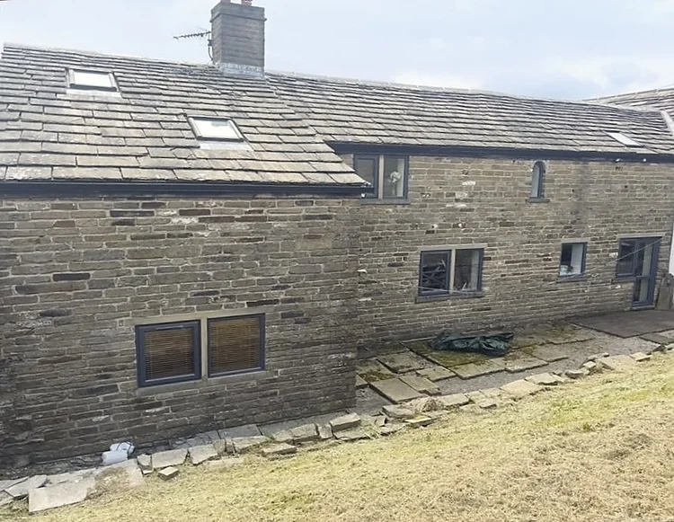 Rear farmhouse stonework before mortar removal
