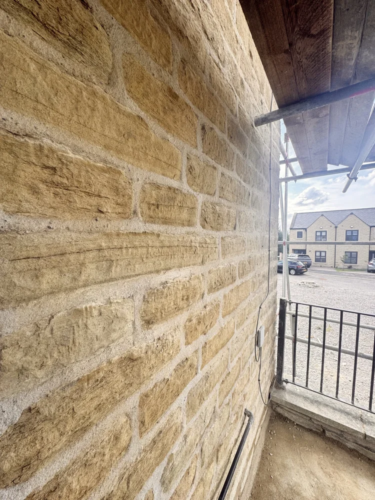 Side view of the property with drying lime mortar joints