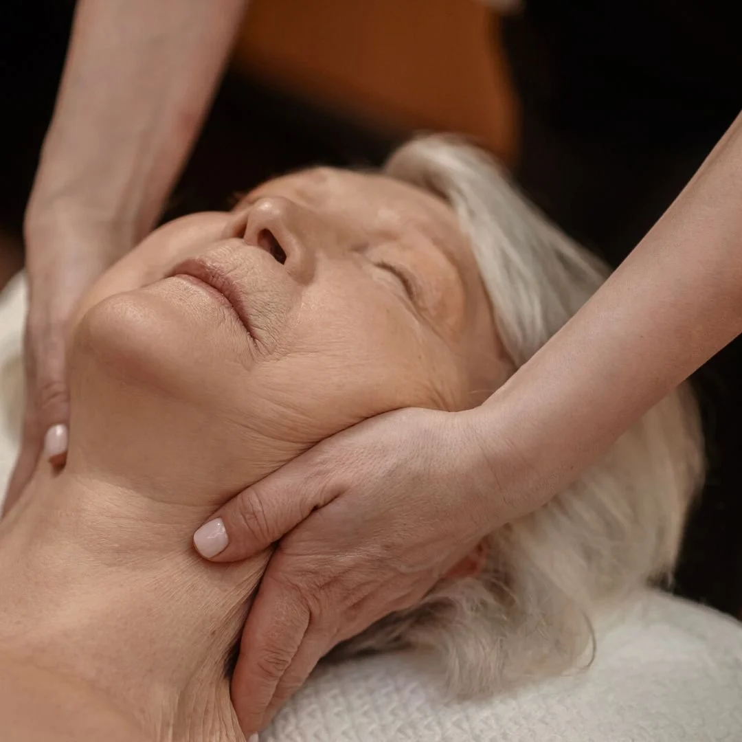 Holly Brewer, licensed massage therapist in Charlotte, performing Upledger Craniosacral Therapy to relieve tension, improve mobility, and support healing.
