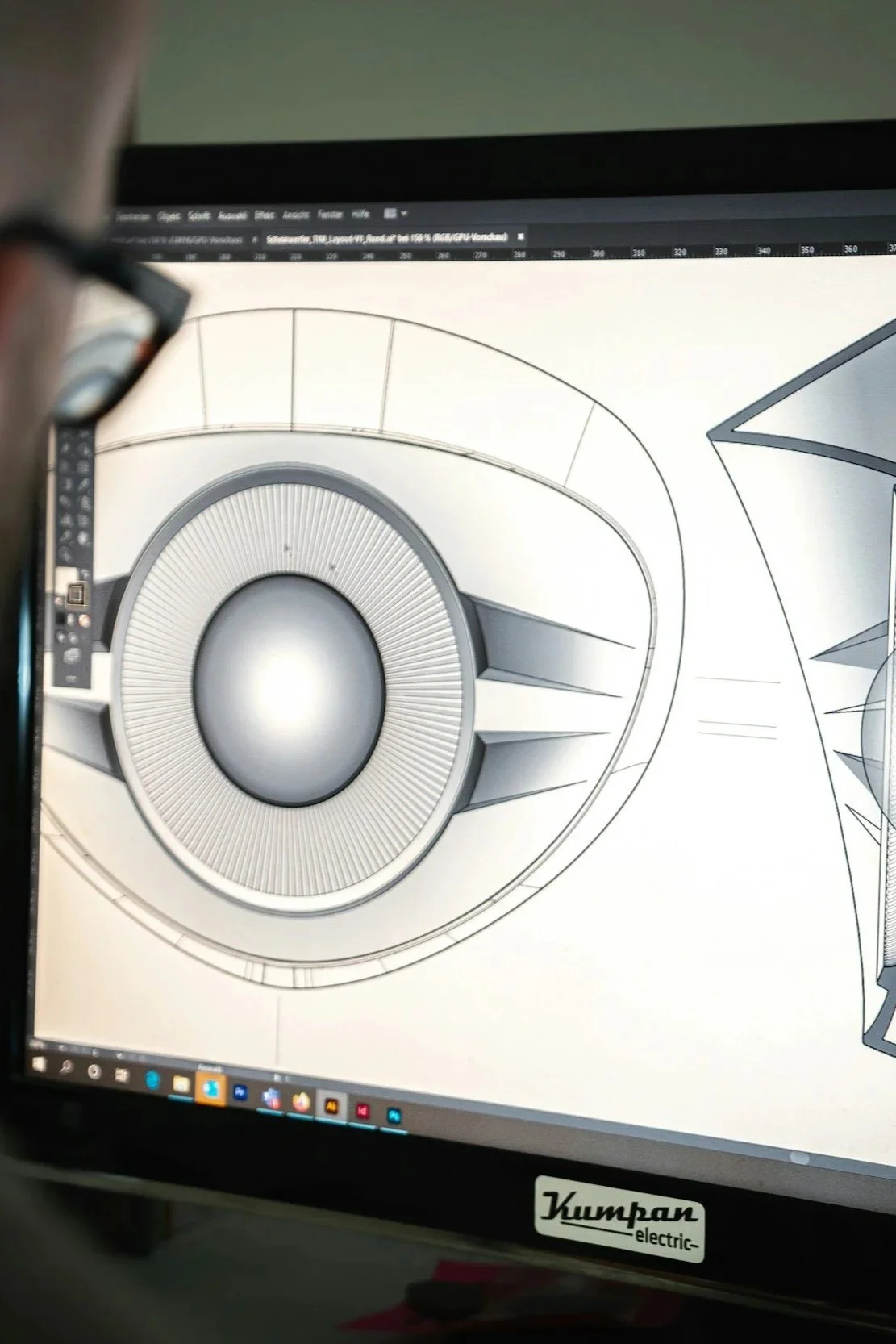 Computer screen displaying a 3D CAD design of a speaker or mechanical component with intricate details.