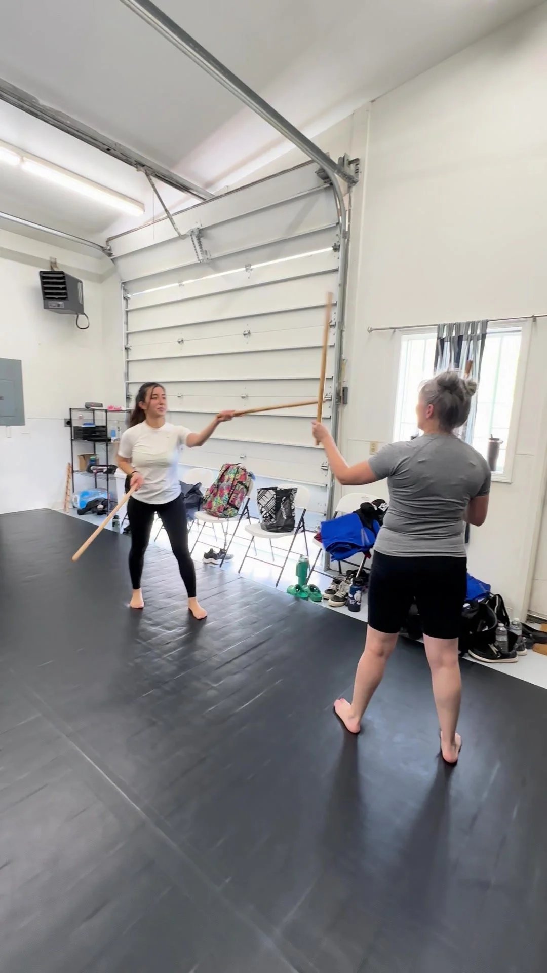 Two students practicing partner stick drills.