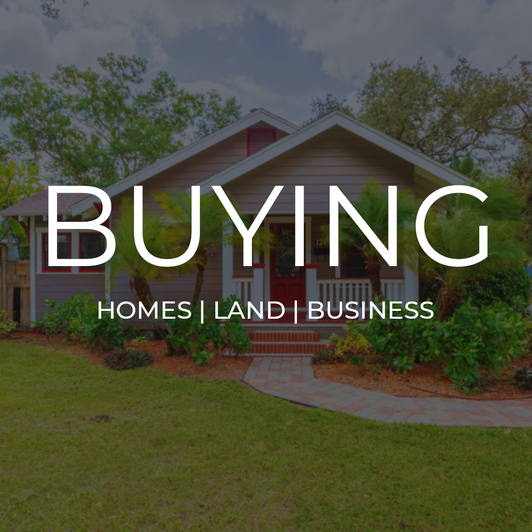 A house with a front porch, surrounded by greenery and trees, with the words 'Buying Homes, Land, and Business' overlaid.