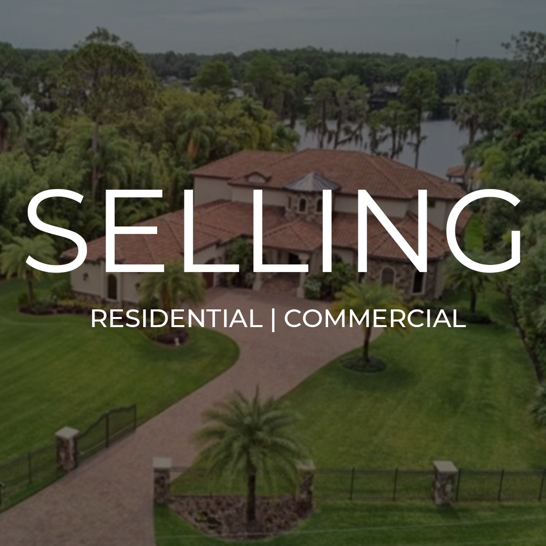 A large residential house with a tiled roof, surrounded by a manicured lawn and trees, overlooking a lake, with the words "Selling Residential and Business" overlaid.