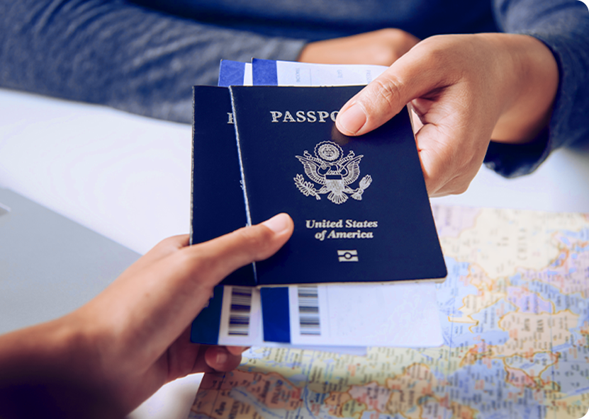 Two people exchanging a U.S. passport and boarding passes over a map.