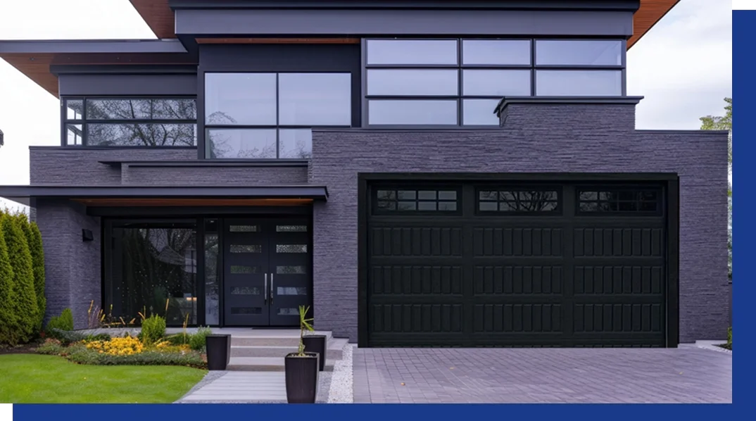 Modern house with a black garage door, large windows, and a landscaped front yard.
