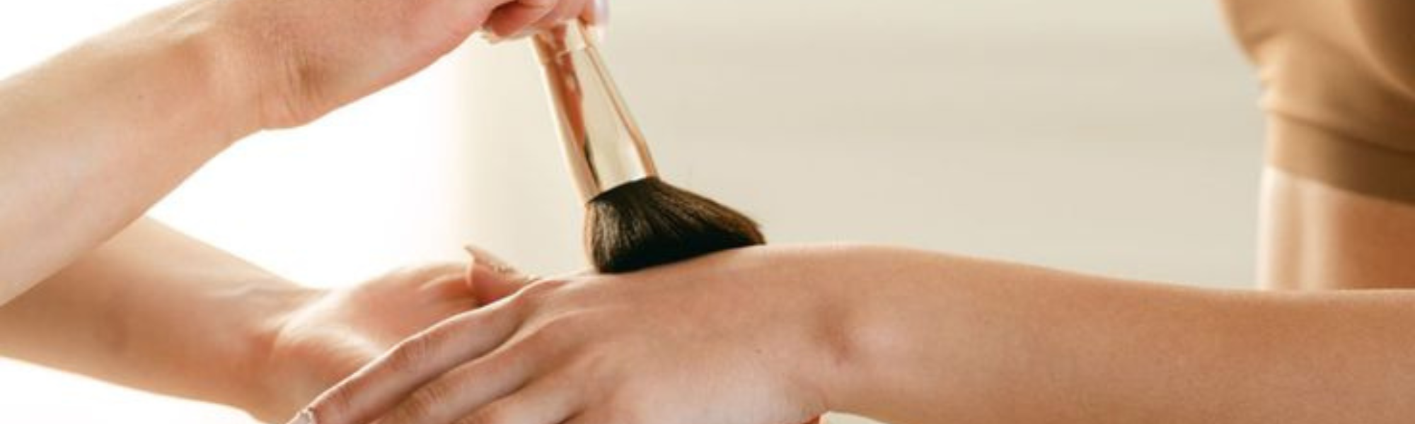 A client getting finishing powder applied after getting a professional spray tan service done