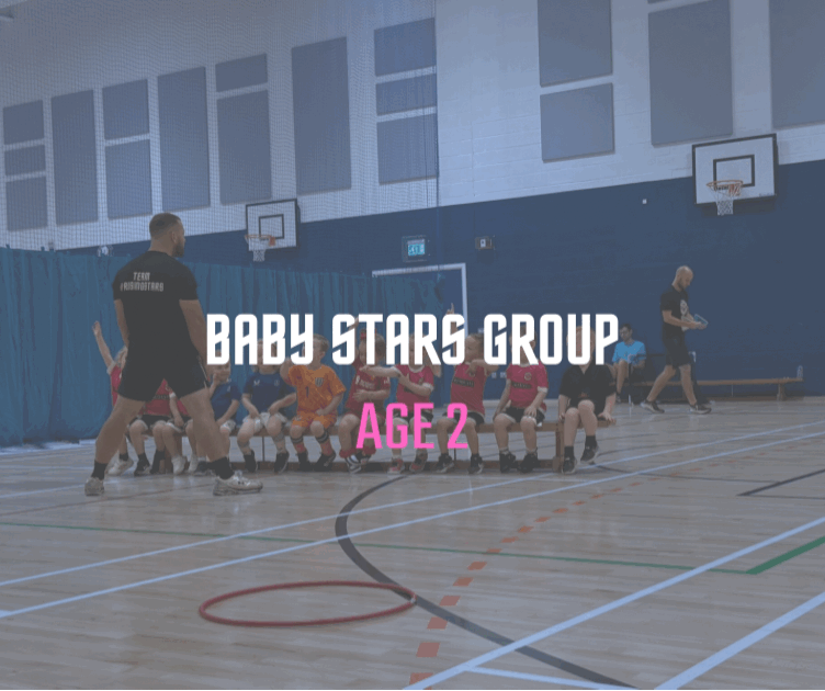 Young children sitting on a gym floor in front of a basketball hoop with two adults. Text overlay reads 'Baby Stars Group, Age 2'.