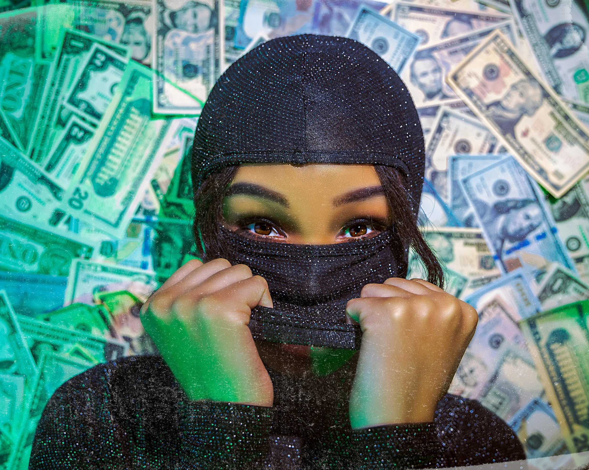 A person wearing a black beanie and face mask with a glittery appearance, holding the mask with both hands, with a background of scattered U.S. dollar bills.
