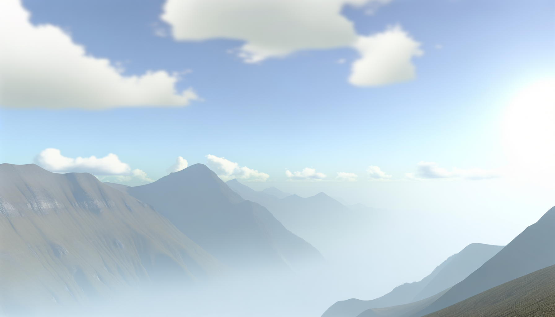 Mountain range with peaks covered in mist and a partly cloudy sky.