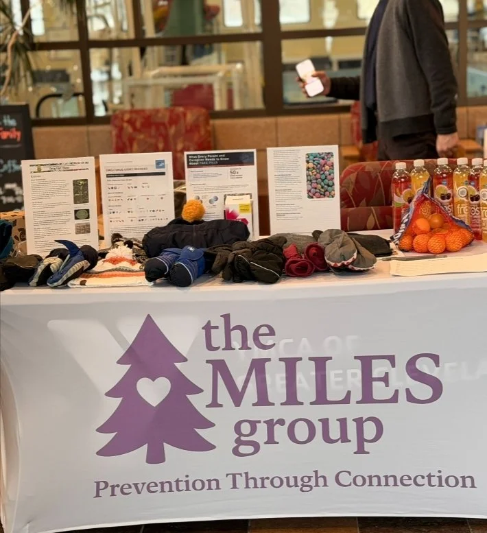 The MILES Group outreach table with educational materials and prevention resources.