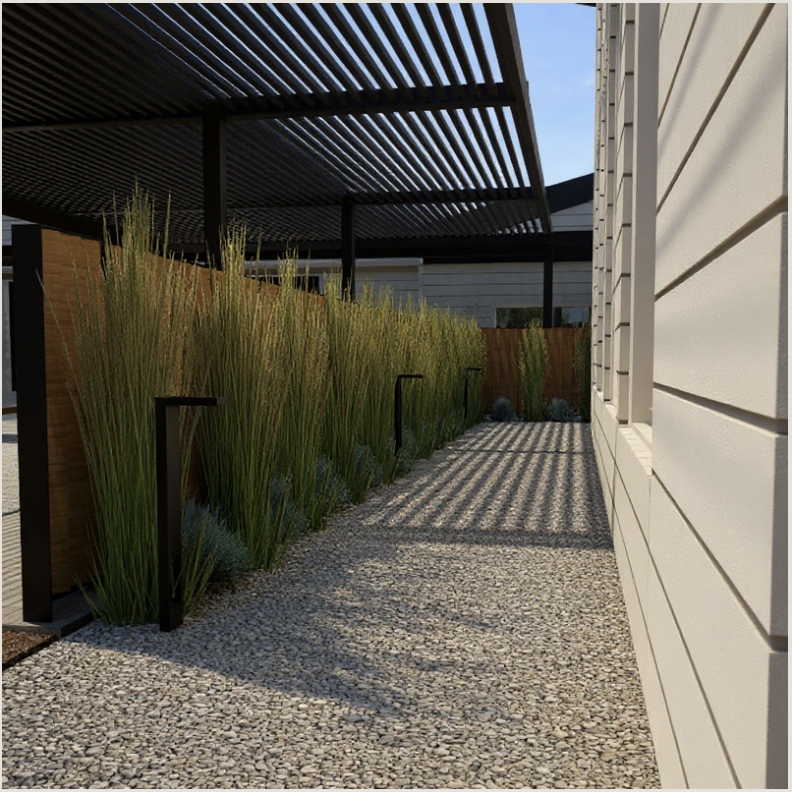 Side yard with gravel pathway, tall ornamental grasses, black metal handrails, wooden privacy fence, and a slatted pergola casting shadows, next to a beige siding house.