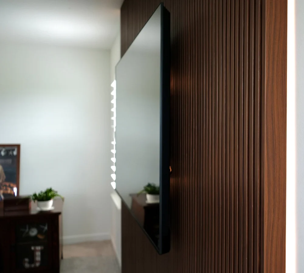 Walnut slat feature wall with integrated lighting and television