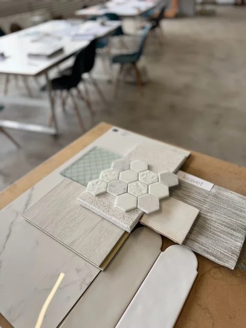 Samples of tile and countertop materials displayed on a open book in a showroom or store.