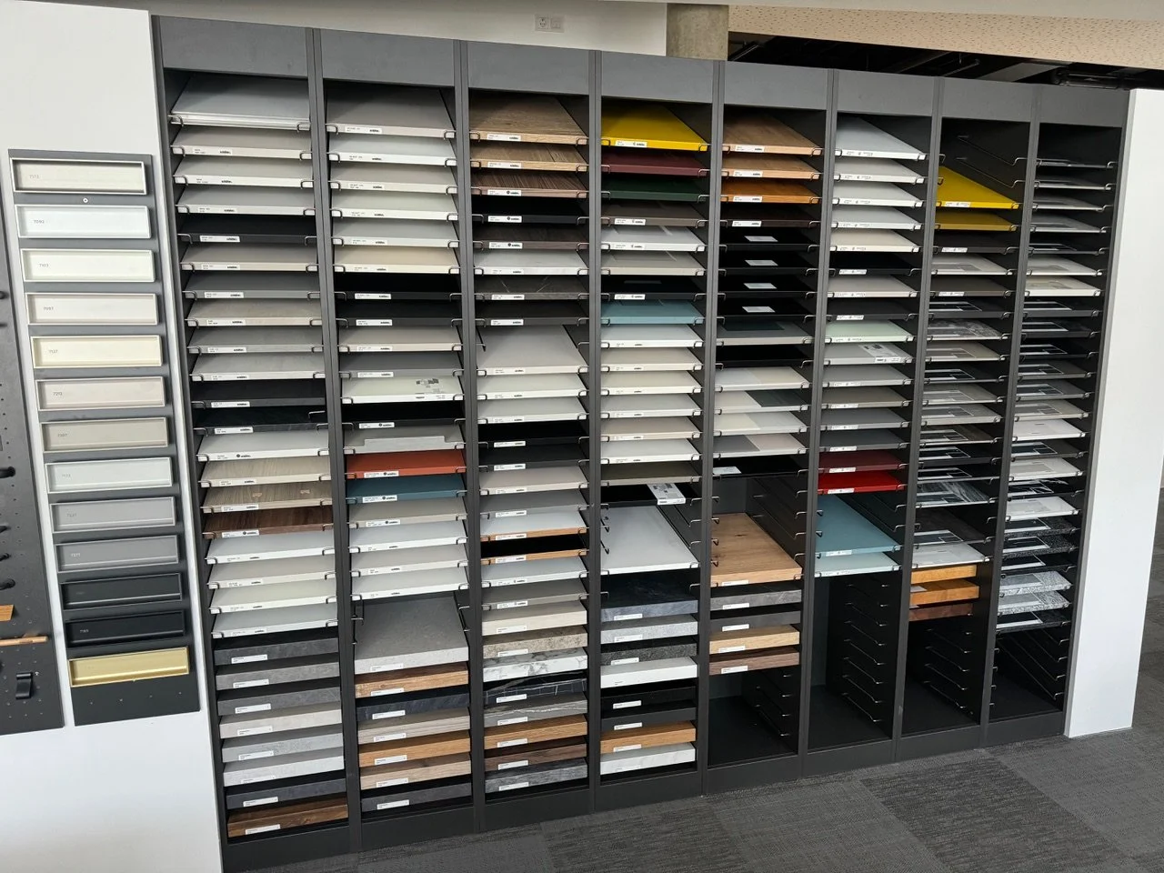 Display of various laminate and surface material samples organized in an office or showroom setting.