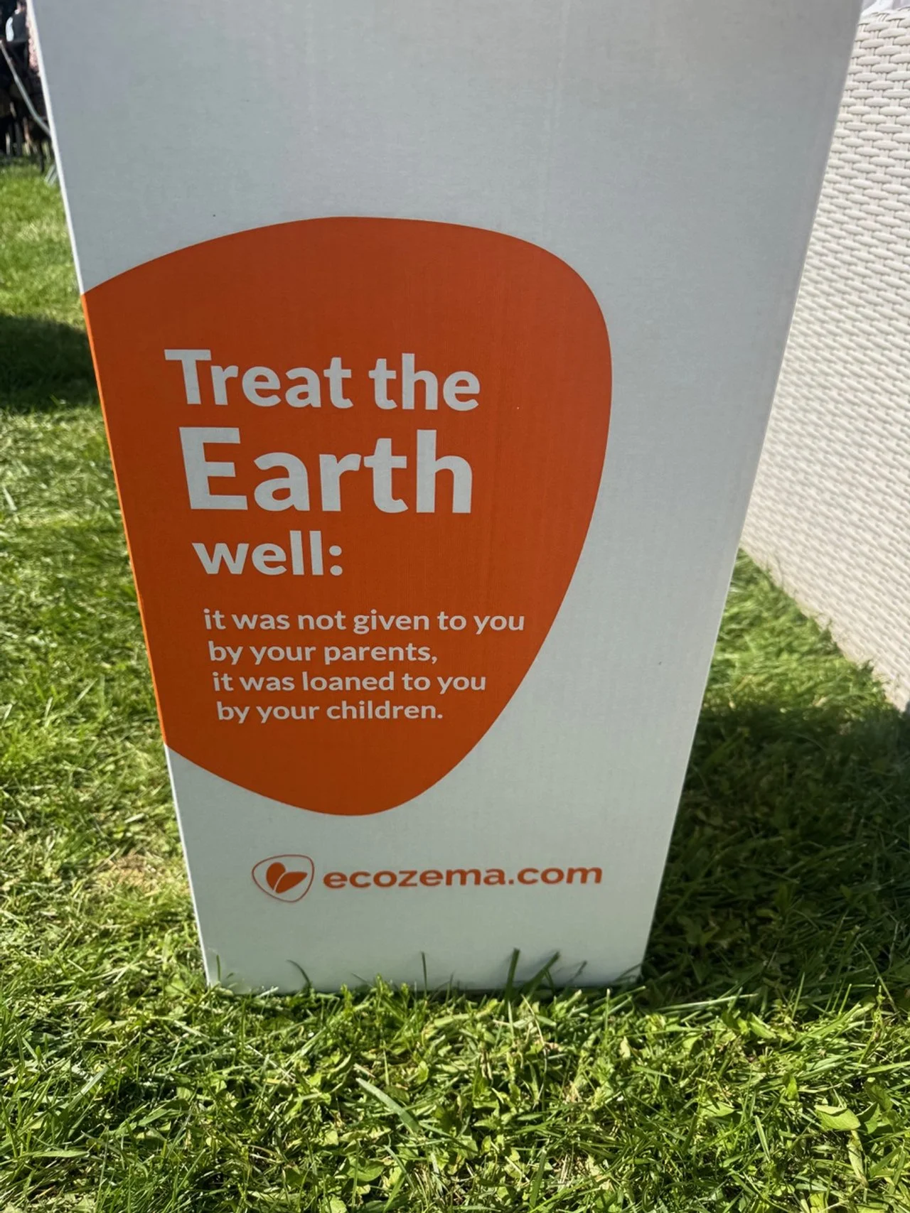Sign with the message 'Treat the Earth well: it was not given to you by your parents, it was loaned to you by your children,' and a website URL 'ecozenia.com' at the bottom.